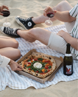 3 cartons à pizzas posés sur une table à Alma Mia Arcachon