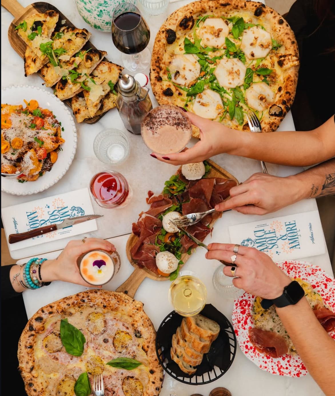 Table d'une pizzeria à Arcachon avec 2 personnes qui mangent un plat de pâte et une pizza