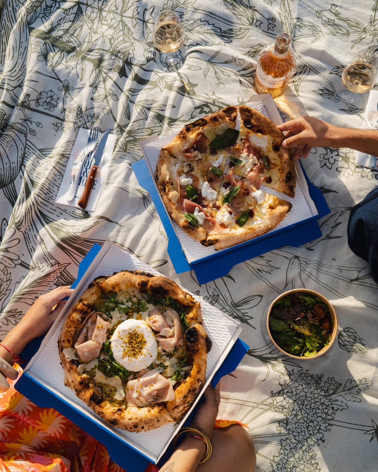 3 cartons à pizzas posés sur une table à Alma Mia Arcachon